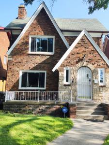 a brick house with a white door and a porch at Huge Historic Home in Detroit