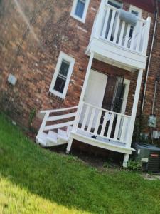 a house with a white door and a porch at Huge Historic Home in Detroit +2 photos