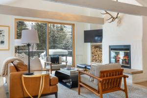 a living room with a couch and a fireplace at Novelle Chalet - Renovated, Chic Contemporary Home on Gore Creek with Hot Tub in Vail