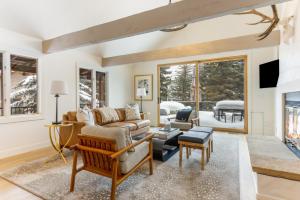 a living room with a couch and a fireplace at Novelle Chalet - Renovated, Chic Contemporary Home on Gore Creek with Hot Tub in Vail