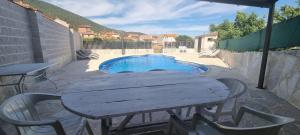 a wooden table and chairs next to a small pool at Tio Claudio in El Barraco