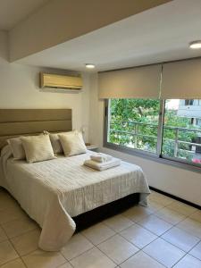 a bedroom with a bed and a large window at Monoambiente13 Zona Catedral by Lofter in La Plata