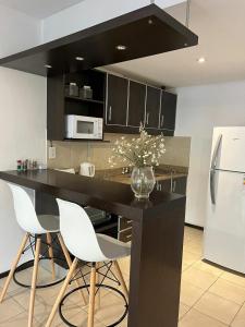 a kitchen with a black counter and white appliances at Monoambiente13 Zona Catedral by Lofter in La Plata