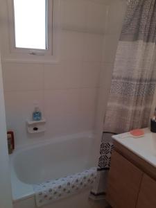 Un baño con bañera y cortina de ducha. en Depto Condominio Laguna Mar, en Las Cruces 9 fotos más