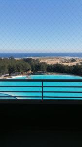 vistas a una piscina a través de una valla de cadena en Depto Condominio Laguna Mar, en Las Cruces