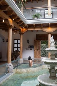 a woman in a swimming pool in a house at Indian Palace Hotel Boutique Spa & Restaurante in Antigua Guatemala