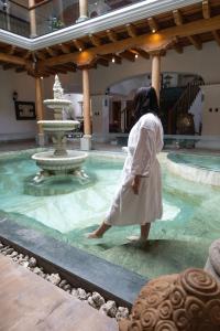 a woman walking in a pool with a fountain at Indian Palace Hotel Boutique Spa & Restaurante in Antigua Guatemala +50 photos