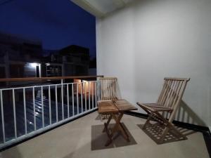 BAROKAH Cordoba Homestay 1 Rumah dgn 3 Kamar في Tlekung: كرسيين يجلسون فوق الشرفة في الليل