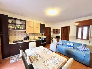 a living room with a blue couch and a kitchen at ORAMA apartment Front sea in Giardini Naxos