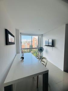a white room with a table and a large window at Grandioso apartaestudio muy cerca a Provenza 201 in Medellín +9 photos