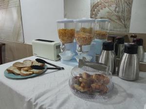 a table with a plate of bread and two containers of food at Life in Maciel
