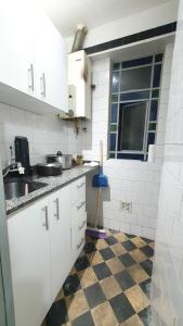 a kitchen with white cabinets and a checkered floor at Hostal 2 in Buenos Aires