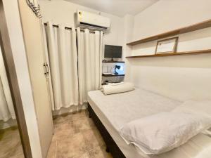 a small room with two beds and curtains at Pousada Family Consulado Americano in São Paulo