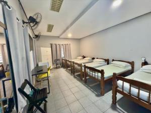 a room with four beds and a desk in it at Pousada Family Consulado Americano in São Paulo