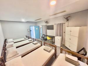 a room with several beds and a refrigerator at Pousada Family Consulado Americano in São Paulo