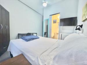 a hospital room with a white bed with a blue pillow at Pousada Family Consulado Americano in São Paulo