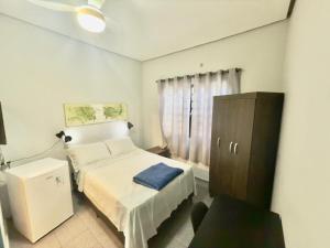 a small bedroom with a bed and a dresser at Pousada Family Consulado Americano in São Paulo