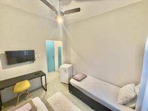a room with a couch and a table and a tv at Pousada Family Consulado Americano in São Paulo