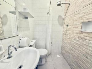 a bathroom with a sink and a toilet and a shower at Pousada Family Consulado Americano in São Paulo