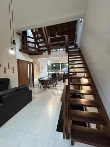 eine Treppe in einem Wohnzimmer mit Sofa und Tisch in der Unterkunft Vilarejo Leme in São Sebastião