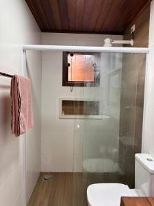 a bathroom with a glass shower and a toilet at Suite novinha para locação em Ilhabela in Ilhabela
