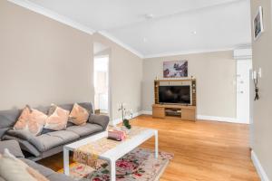 ein Wohnzimmer mit Sofa und Fernseher in der Unterkunft Quaint 2 bedroom fully furnished Cottage in Warwick