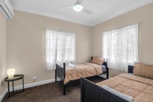 ein Schlafzimmer mit zwei Betten und einer Couch in der Unterkunft Quaint 2 bedroom fully furnished Cottage in Warwick