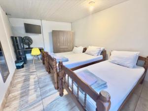 a room with two beds and a chair in it at Pousada Family Consulado Americano in São Paulo