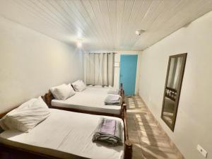 a room with three beds and a mirror at Pousada Family Consulado Americano in São Paulo