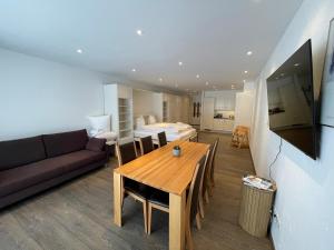 a living room with a wooden table and a couch at Apartment with Pool, Sauna & Gym in Laax