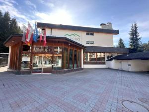 a large building with flags in front of it at Apartment with Pool, Sauna & Gym in Laax
