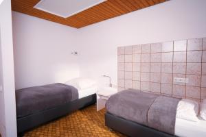 ein kleines Schlafzimmer mit 2 Betten und einem Nachttisch in der Unterkunft Einfache Unterkunft in Michelstadt