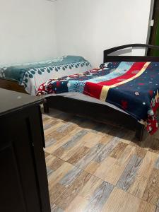 a bedroom with two beds and a wooden floor at Atardecer De Salento in Salento