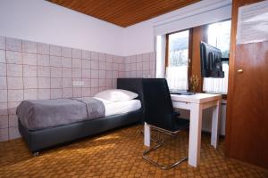 ein Schlafzimmer mit einem Bett und einem Schreibtisch mit einem Computer in der Unterkunft Einfache Unterkunft in Michelstadt