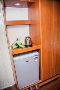 a kitchen with a small refrigerator in a cabinet at Taipei Hua Zhung Campsite in Taipei