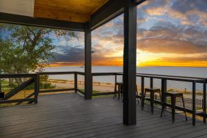 a deck with two chairs and a sunset at Waterfront Home with Views - Hot Tub & Movie Theatre in Bacliff +40 photos