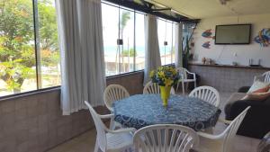 a living room with a table with a vase of flowers on it at Encanto da Lagoa in Iguaba Grande