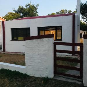 科洛尼亚-德尔萨克拉门托La Casa Del Mercader的一座带围栏的白色小房子