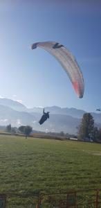 eine Person, die einen Fallschirm auf einem Feld reitet in der Unterkunft Gîte fabuleux, jardin, terrasse, parking in Saint-Vincent-de-Mercuze
