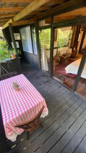 - une terrasse couverte en bois avec une table et un lit dans l'établissement Chalé Rustic House, à Campos do Jordão