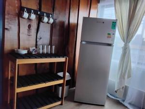 a refrigerator in a kitchen next to a table at Hostal Maravillas del Sur in Villarrica
