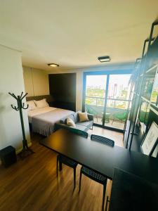クイアバにあるStudio Cuiabá NOVO - Frente ao Shopping Estaçãoのベッドとテーブルのあるホテルの部屋 +21枚の写真
