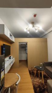 a living room with a couch and a table at Lucky One! Staycation Trees Residences Near SM Fairview in Manila