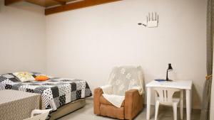 a bedroom with a bed and a chair and a table at Tiny House - Centro Concórdia in Concordia