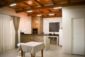 a kitchen with a table and a white refrigerator at Tiny House - Centro Concórdia in Concordia