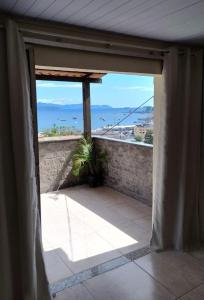 an open door to a balcony with a view of the ocean at Casa Familiar no Centro de Angra in Angra dos Reis