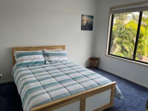 a bedroom with a bed with a large window at 12 Tingira Close Rainbow Beach in Rainbow Beach +10 photos