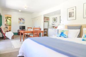 a bedroom with a bed and a dining room at Annabells B&B in Whitianga