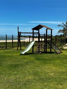 einen Spielplatz mit Rutsche und Spielstruktur in der Unterkunft Village Itacimirim Boulevard - Pé na areia in Itacimirim