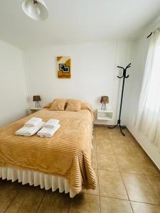 a bedroom with a bed with two towels on it at Pueblo Dorado in Malargüe